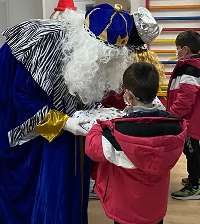 Melchor entregando un regalo a un niño